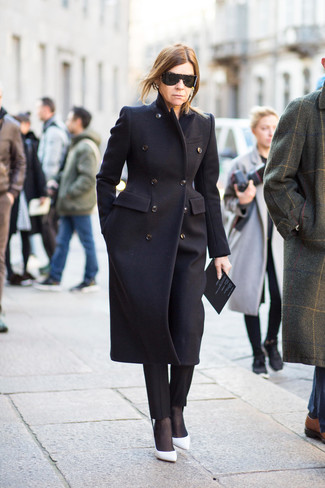 Comment s'habiller après 50 ans: Associer un manteau noir avec un pantalon carotte noir est une option judicieux pour une journée au bureau. Une paire de des escarpins en cuir blancs est une option astucieux pour complèter cette tenue.