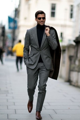 Comment porter un costume gris foncé quand il fait frais: Opte pour un costume gris foncé avec un pardessus noir pour dégager classe et sophistication. Termine ce look avec une paire de chaussures richelieu en cuir marron.