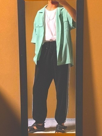 Comment porter un t-shirt à col rond rose avec un pantalon de jogging noir