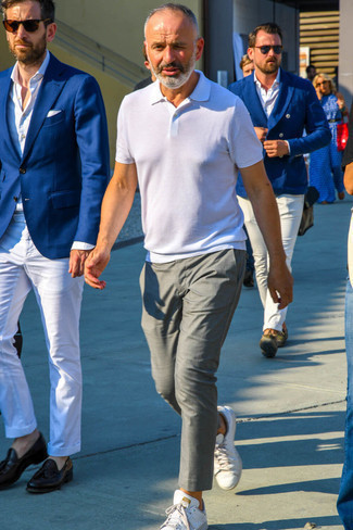 Comment porter des baskets basses blanc et bleu marine pour un style decontractés après 50 ans: Pour créer une tenue idéale pour un déjeuner entre amis le week-end, pense à marier un polo blanc avec un pantalon chino gris. Cette tenue est parfait avec une paire de baskets basses blanc et bleu marine.