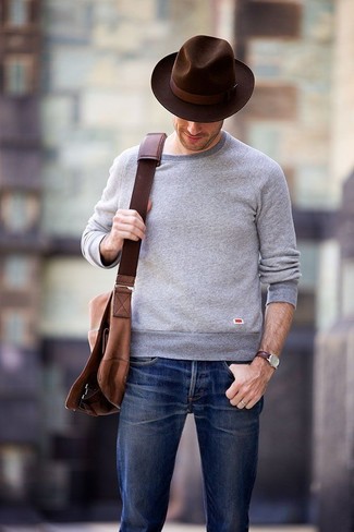 Comment porter une besace en toile marron foncé: Choisis un pull à col rond gris et une besace en toile marron foncé pour un look idéal le week-end.