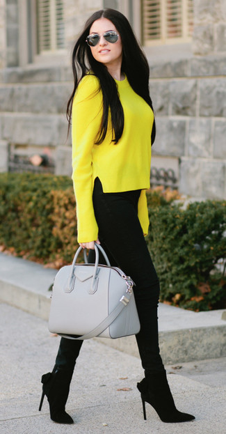 Comment s'habiller à 20 ans: Choisis un pull à col rond jaune et un jean skinny noir pour obtenir un look relax mais stylé. Une paire de des bottines en daim noires s'intégrera de manière fluide à une grande variété de tenues.