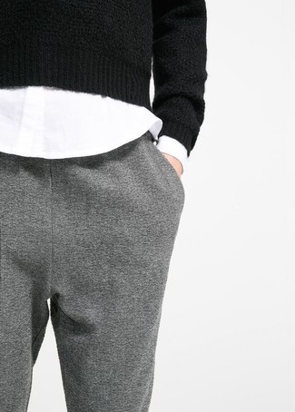 Comment porter un pantalon carotte gris: Pour créer une tenue idéale pour un déjeuner entre amis le week-end, marie un pull à col rond noir avec un pantalon carotte gris.