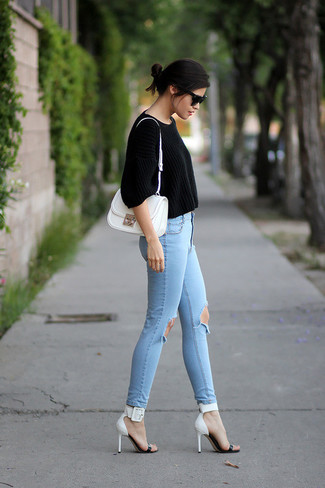Comment porter un jean déchiré bleu clair: Essaie d'harmoniser un pull court noir avec un jean déchiré bleu clair pour une tenue relax mais stylée. Complète ce look avec une paire de sandales à talons en cuir blanches et noires.
