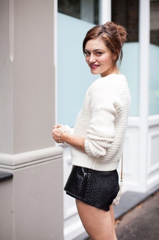 Essaie d'harmoniser un pull torsadé blanc avec un short en cuir noir pour créer un style chic et glamour.