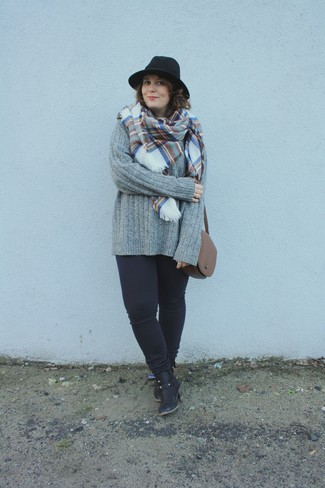 Comment porter un pull torsadé gris: Associe un pull torsadé gris avec un jean skinny noir pour obtenir un look relax mais stylé. Assortis ce look avec une paire de bottines en cuir noires.