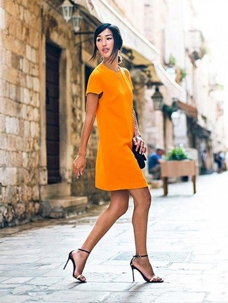Comment porter des sandales à talons en cuir noir et doré: Porte une robe droite orange pour un look élégant et soigné. Complète ce look avec une paire de sandales à talons en cuir noir et doré.