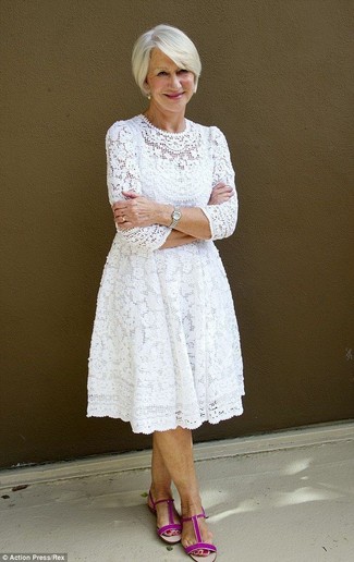 Comment s'habiller après 60 ans: Choisis une robe midi en dentelle blanche pour une tenue confortable aussi composée avec goût. Si tu veux éviter un look trop formel, termine ce look avec une paire de des sandales plates en daim fuchsia.