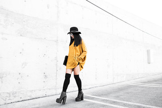 Comment porter des bottines en cuir épaisses noires: Choisis une robe-pull moutarde pour affronter sans effort les défis que la journée te réserve. Complète ce look avec une paire de bottines en cuir épaisses noires.