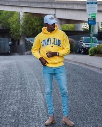 Comment porter un sweat à capuche imprimé jaune: Marie un sweat à capuche imprimé jaune avec un jean skinny bleu clair pour un look confortable et décontracté. Une paire de bottines chelsea en daim marron clair apportera une esthétique classique à l'ensemble.