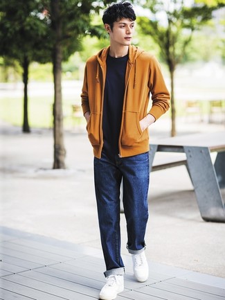 Comment porter un sweat à capuche orange: Porte un sweat à capuche orange et un jean bleu marine pour une tenue confortable aussi composée avec goût. Complète ce look avec une paire de baskets basses en cuir blanches.