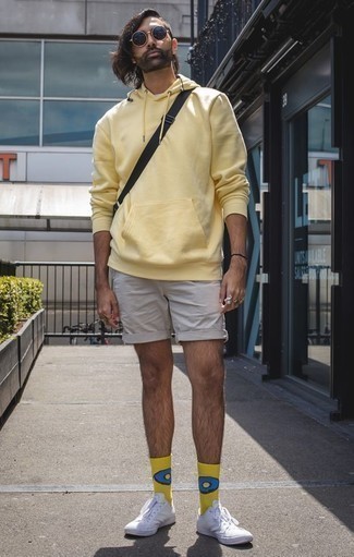 Comment porter un short marron clair: Associe un sweat à capuche jaune avec un short marron clair pour une tenue idéale le week-end. Complète ce look avec une paire de baskets basses en toile blanches.