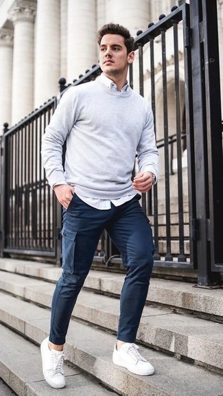 Comment porter un sweat-shirt gris foncé pour un style decontractés à 30 ans: Pour une tenue de tous les jours pleine de caractère et de personnalité essaie d'associer un sweat-shirt gris foncé avec un pantalon cargo bleu marine. Complète ce look avec une paire de baskets basses en cuir blanches.