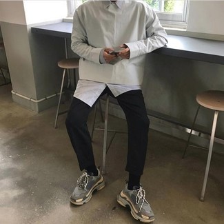Comment porter un sweat-shirt gris: Pense à harmoniser un sweat-shirt gris avec un pantalon chino noir pour obtenir un look relax mais stylé. Tu veux y aller doucement avec les chaussures? Fais d'une paire de chaussures de sport grises ton choix de souliers pour la journée.