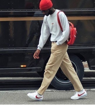 Tenue: Sweat-shirt gris, Pantalon chino marron clair, Baskets basses blanc et rouge, Sac à dos rouge