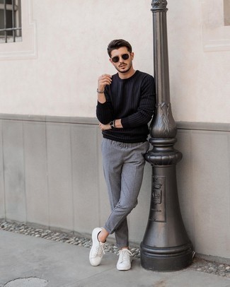 Comment porter un sweat-shirt noir: Pense à porter un sweat-shirt noir et un pantalon chino gris pour obtenir un look relax mais stylé. Complète ce look avec une paire de baskets basses en cuir blanches.