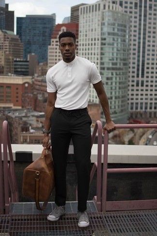 Tenue: T-shirt à col boutonné blanc, Pantalon chino noir, Baskets montantes en toile grises, Fourre-tout en cuir marron