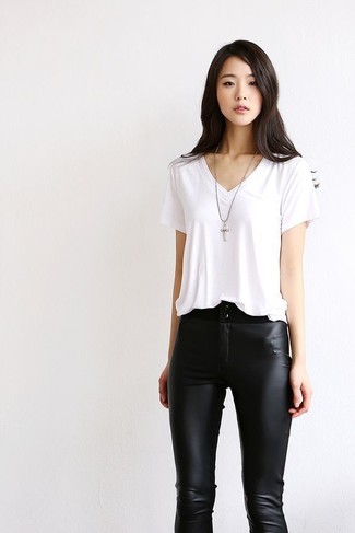 Tenue: T-shirt à col en v blanc, Pantalon slim en cuir noir, Pendentif argenté