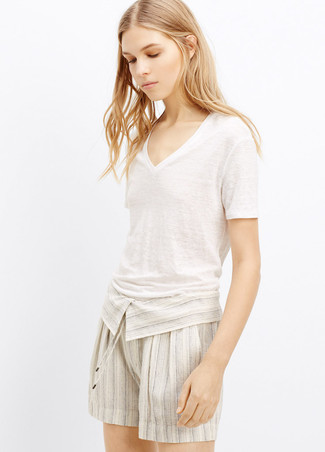 Comment porter un short en lin beige: Associe un t-shirt à col en v blanc avec un short en lin beige pour créer un style chic et glamour.
