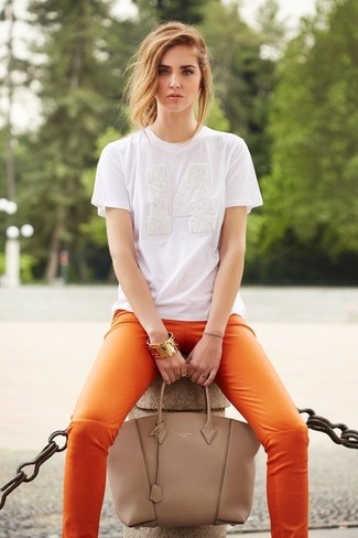 Comment porter un pantalon slim en cuir orange: Marie un t-shirt à col rond blanc avec un pantalon slim en cuir orange pour achever un look chic.