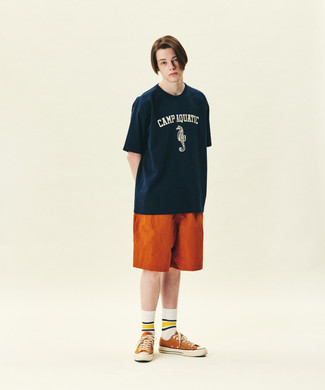 Tenue: T-shirt à col rond imprimé bleu marine et blanc, Short orange, Baskets basses en toile orange, Chaussettes à rayures horizontales blanches