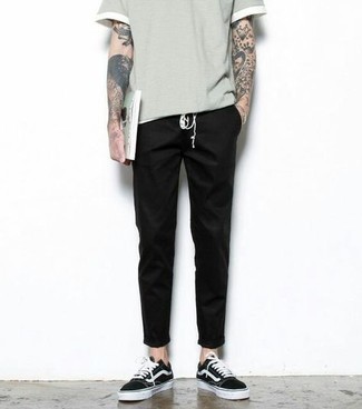 Tenue: T-shirt à col rond gris, Pantalon chino noir, Baskets basses en toile noires et blanches, Montre argentée
