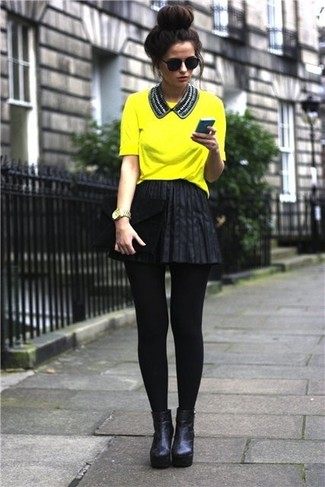 Comment porter une jupe patineuse en cuir noire: Pense à marier un t-shirt à col rond jaune avec une jupe patineuse en cuir noire pour créer un look génial et idéal le week-end. Cette tenue est parfait avec une paire de bottines en cuir noires.