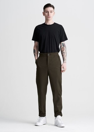 Tenue: T-shirt à col rond noir, Pantalon chino marron foncé, Baskets basses en cuir blanches, Chaussettes blanches