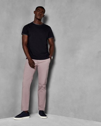 Comment porter un pantalon chino rose à 20 ans: Pour une tenue de tous les jours pleine de caractère et de personnalité essaie d'harmoniser un t-shirt à col rond noir avec un pantalon chino rose. Une paire de baskets basses en daim bleu marine est une option parfait pour complèter cette tenue.