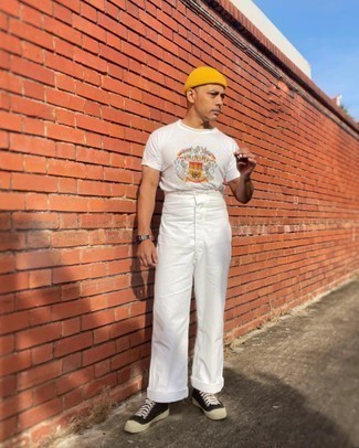 Tendances mode hommes: Opte pour un t-shirt à col rond imprimé blanc avec un pantalon chino blanc pour une tenue confortable aussi composée avec goût. Cet ensemble est parfait avec une paire de baskets basses en toile noires et blanches.