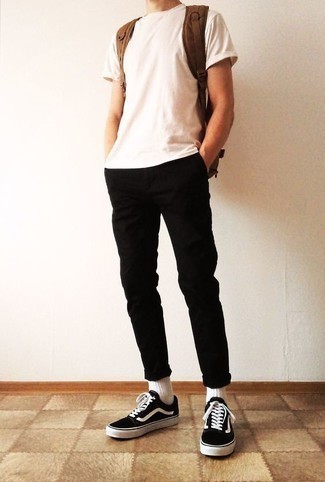 Tenue: T-shirt à col rond blanc, Pantalon chino noir, Baskets basses en toile noires et blanches, Sac à dos en toile marron
