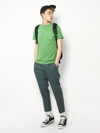 Tenue: T-shirt à col rond vert, Pantalon chino vert foncé, Baskets basses en toile noires et blanches, Sac à dos en toile noir
