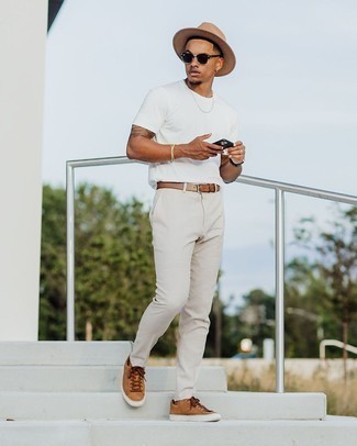 Comment porter des baskets basses en toile marron clair: Opte pour un t-shirt à col rond blanc avec un pantalon chino beige pour une tenue idéale le week-end. Complète ce look avec une paire de baskets basses en toile marron clair.