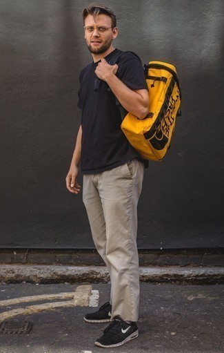 Comment porter un grand sac en toile jaune: Pense à harmoniser un t-shirt à col rond noir avec un grand sac en toile jaune pour un look idéal le week-end. Une paire de chaussures de sport noires et blanches ajoutera de l'élégance à un look simple.