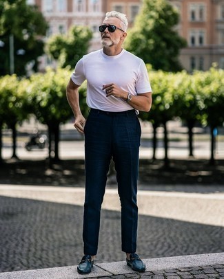 Comment porter un t-shirt blanc et noir quand il fait très chaud après 50 ans: Essaie d'harmoniser un t-shirt blanc et noir avec un pantalon de costume en lin bleu marine pour prendre un verre après le travail. Choisis une paire de slippers en cuir bleu marine pour afficher ton expertise vestimentaire.