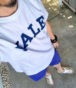 Tenue: T-shirt à col rond imprimé blanc et bleu marine, Short de running bleu marine, Tongs en cuir blanches, Montre en cuir noire