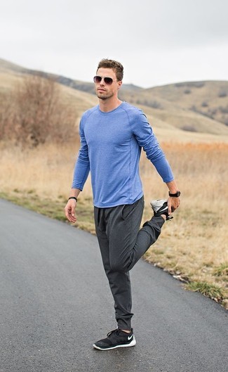 Comment porter un pantalon de jogging gris: Opte pour un t-shirt à manche longue bleu avec un pantalon de jogging gris pour un look idéal le week-end. Une paire de chaussures de sport noires est une option génial pour complèter cette tenue.