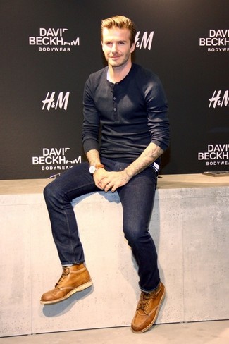 Tenue de David Beckham: T-shirt à manche longue et col boutonné noir, Jean bleu marine, Bottes de loisirs en cuir marron clair, Montre en cuir marron
