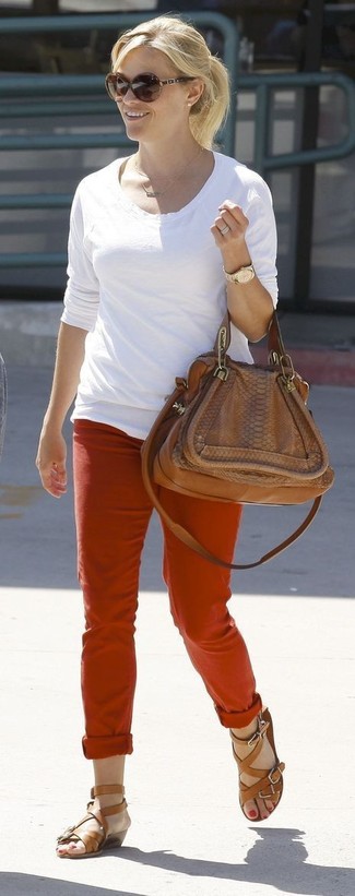 Tenue de Reese Witherspoon: T-shirt à manche longue blanc, Pantalon chino rouge, Sandales spartiates en cuir marron, Cartable en cuir marron
