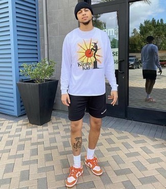 Tenue: T-shirt à manche longue imprimé blanc, Short de running noir, Baskets basses en cuir orange, Bonnet noir