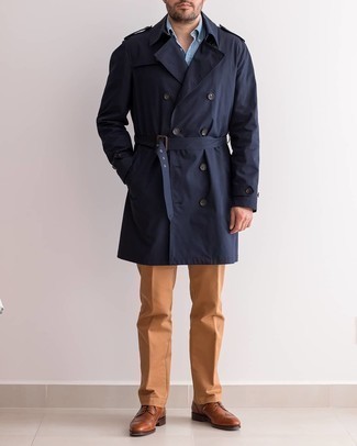 Comment porter un trench bleu à 30 ans: Pense à associer un trench bleu avec un pantalon chino tabac pour aller au bureau. Une paire de chaussures brogues en cuir marron est une façon simple d'améliorer ton look.