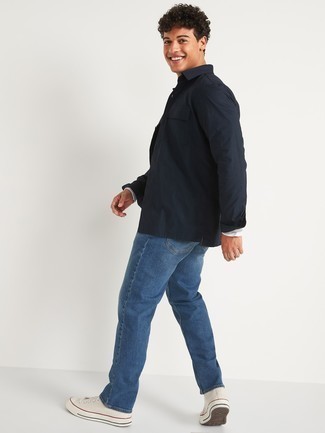 Comment s'habiller à 20 ans: Pense à harmoniser une veste-chemise bleu marine avec un jean bleu pour obtenir un look relax mais stylé. Décoince cette tenue avec une paire de baskets montantes en toile blanches.