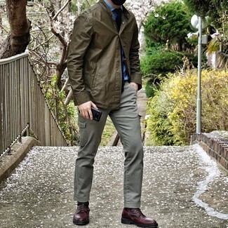 Comment porter des bottes bordeaux: Choisis une veste-chemise olive et un pantalon cargo gris pour un look de tous les jours facile à porter. Rehausse cet ensemble avec une paire de bottes bordeaux.