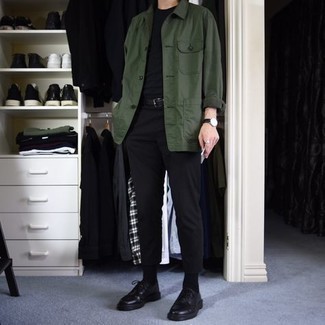 Tenue: Veste-chemise vert foncé, T-shirt à col rond noir, Pantalon chino noir, Chaussures derby en cuir noires