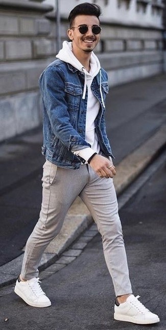 Comment porter une veste en jean bleue avec un pantalon chino en laine gris quand il fait chaud: Pense à harmoniser une veste en jean bleue avec un pantalon chino en laine gris pour une tenue idéale le week-end. Décoince cette tenue avec une paire de baskets basses en cuir blanches.