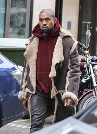 Tenue de Kanye West: Veste en peau de mouton retournée marron foncé, Sweat à capuche en velours bordeaux, Jean en cuir noir