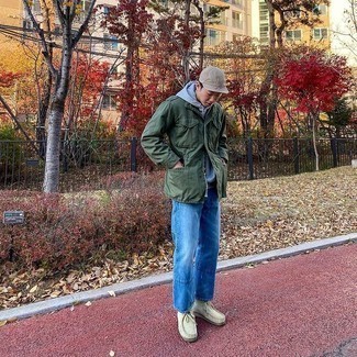 Comment s'habiller à 20 ans: Essaie d'associer un veste militaire vert foncé avec un jean bleu pour obtenir un look relax mais stylé. Cette tenue est parfait avec une paire de bottines chukka en daim beiges.