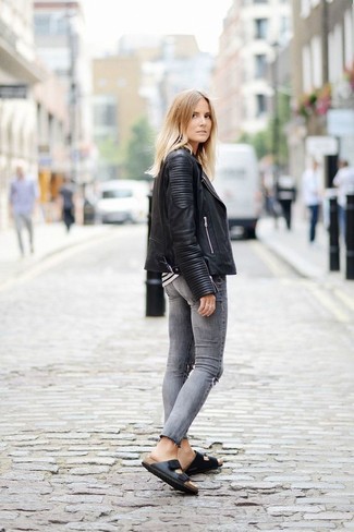 Comment porter un jean déchiré gris: Choisis une veste motard en cuir matelassée noire et un jean déchiré gris pour une impression décontractée. Assortis ce look avec une paire de sandales plates en cuir noires.