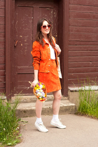Tenue: Veste motard en daim orange, T-shirt à col rond blanc, Jupe trapèze en daim orange, Baskets basses en toile blanches