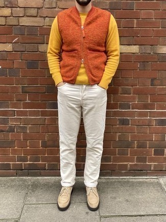 Comment porter des bottines chukka en daim beiges: Associe une veste sans manches en polaire orange avec un jean blanc pour un look de tous les jours facile à porter. Assortis ce look avec une paire de bottines chukka en daim beiges.
